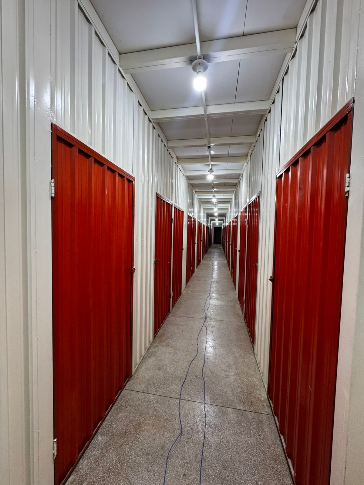 Corredor longo com boxes laranja iluminados